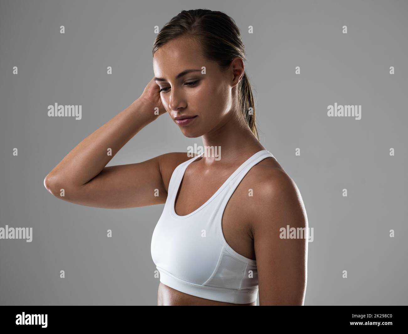 Tout le contenu après un grand entraînement. Une femme attrayante poussant un poil errant derrière son oreille pendant un entraînement. Banque D'Images