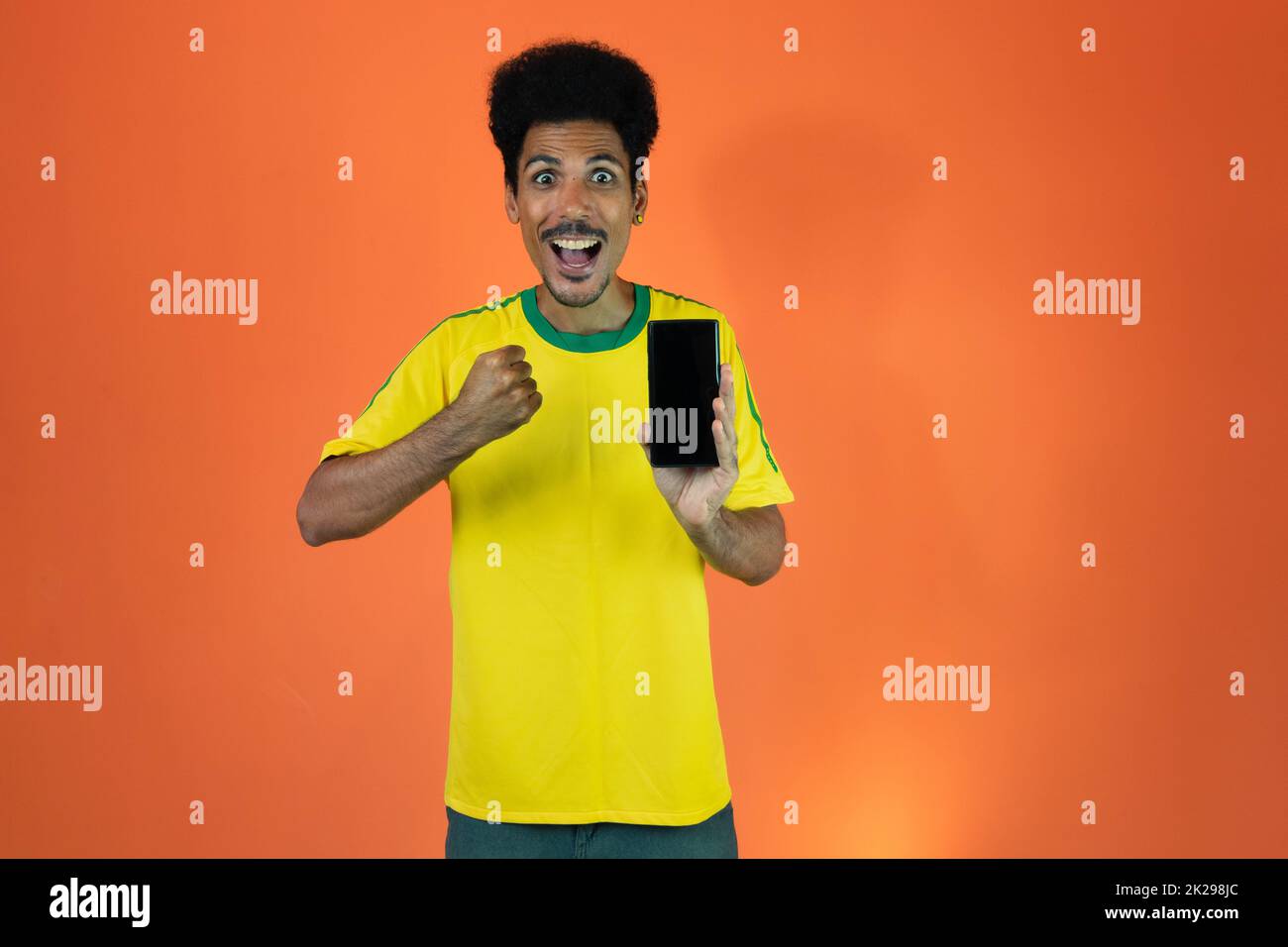 Joueur brésilien - Black Man Celebrating with Yellow T shirt Isolated Banque D'Images