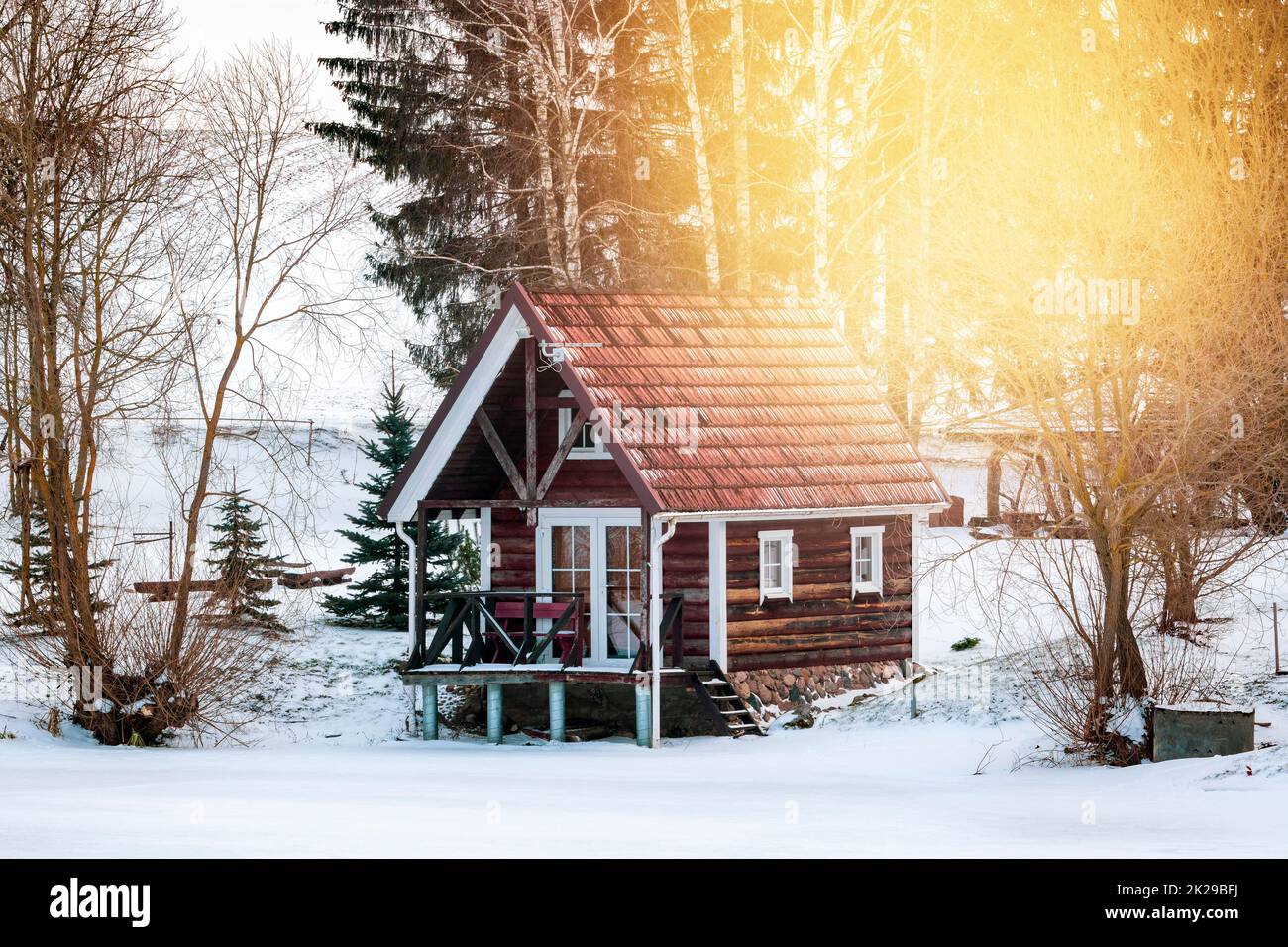 Petit Lodge en bois sur la rive du lac gelé Banque D'Images