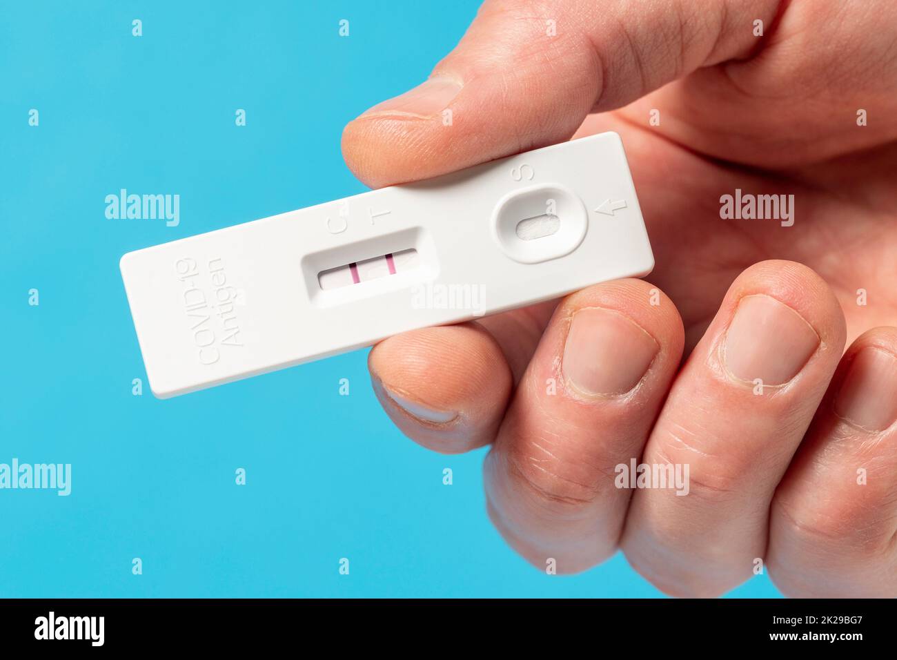 Main montrant le résultat positif du test Covid-19 avec le kit de test rapide de l'antigène du COV-2 du SRAS Banque D'Images