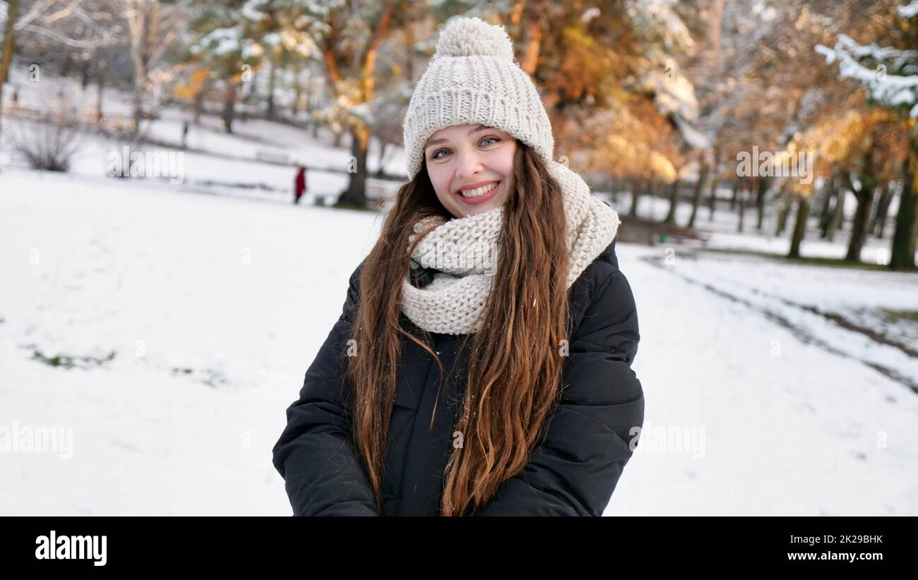 Une femme heureuse marche dans le parc d'hiver Banque D'Images