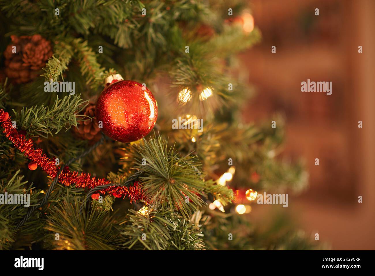 Joyeux Noël étincelant. Gros plan d'un ornement de noël rouge suspendu sur l'arbre Banque D'Images