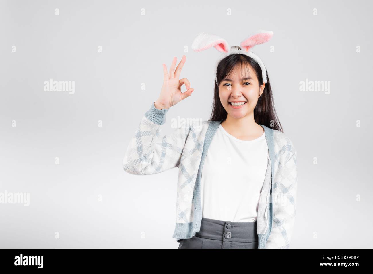 Sourire une femme heureuse portant des oreilles de lapin montre OK signe de doigt Banque D'Images