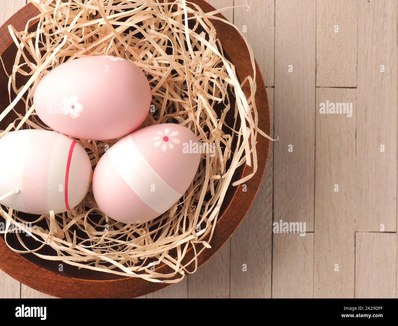 Trois œufs de Pâques roses dans un nid Banque D'Images