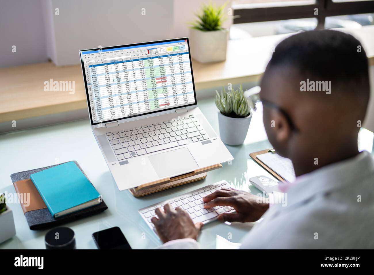 Analyste de données African Man à l'aide de la feuille de calcul Banque D'Images