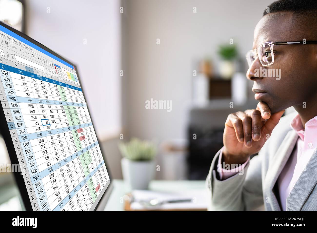 Analyste de données African Man à l'aide de la feuille de calcul Banque D'Images