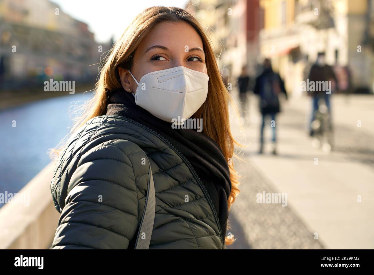 Portrait d'une femme décontractée avec KN95 FFP2 masques de protection tourne autour et regardant loin dans la ville Banque D'Images