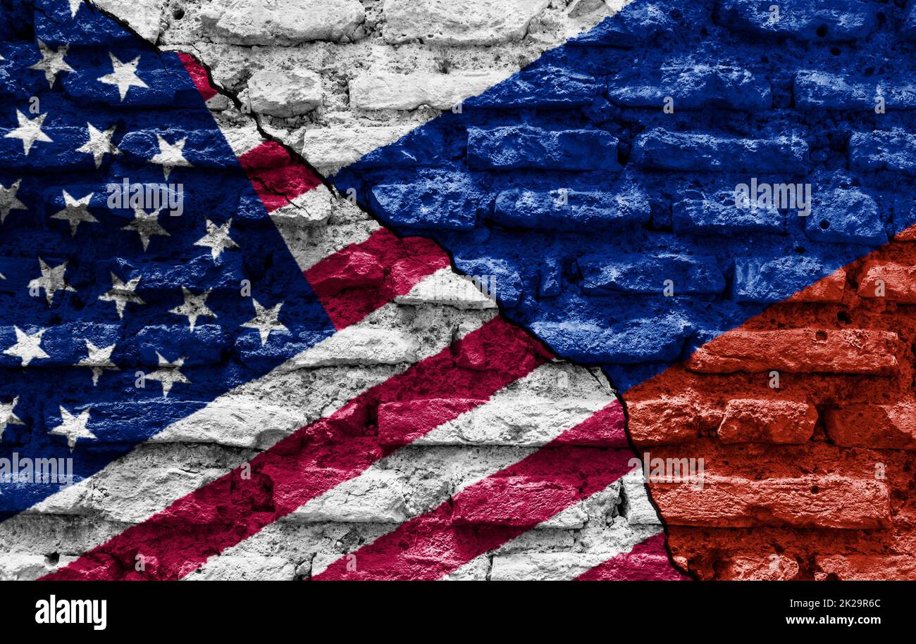 Les drapeaux des États-Unis et de la Russie peints sur un mur en ruines et divisés par une fissure diagonale. Banque D'Images