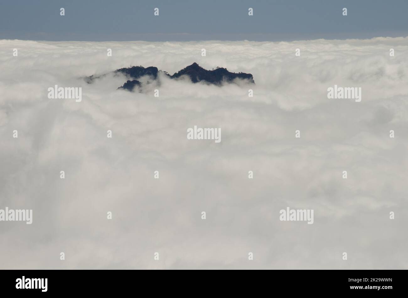 Crag dans une mer de nuages. Banque D'Images