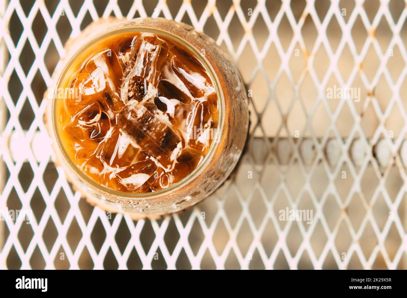 Café latte glacé dans un verre avec de la crème sur le fond. Arrière-plan de boisson d'été froide Banque D'Images