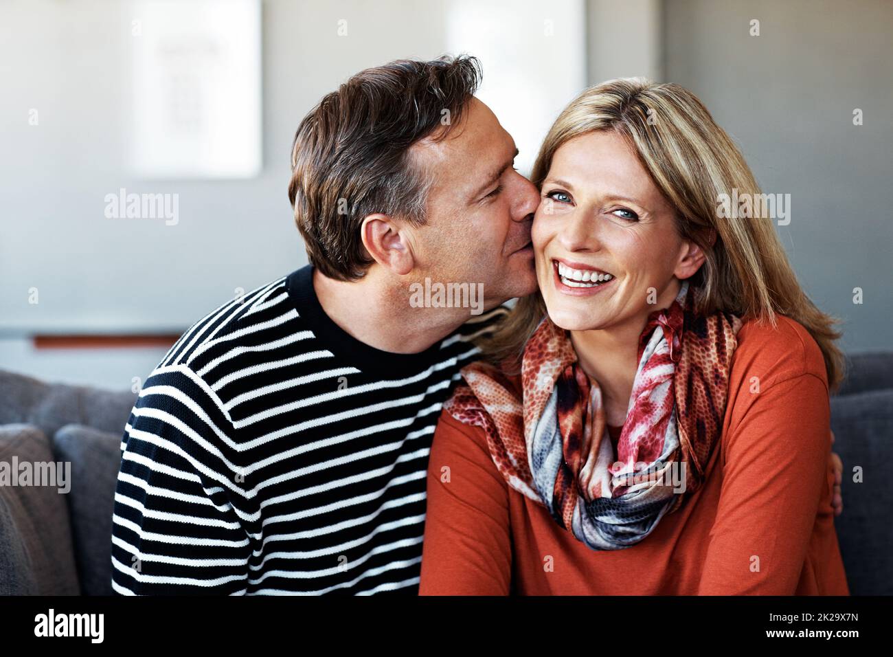 Baisers pour ses tissus. Photo d'un couple affectueux et mûr se détendant ensemble sur le canapé de leur salon. Banque D'Images