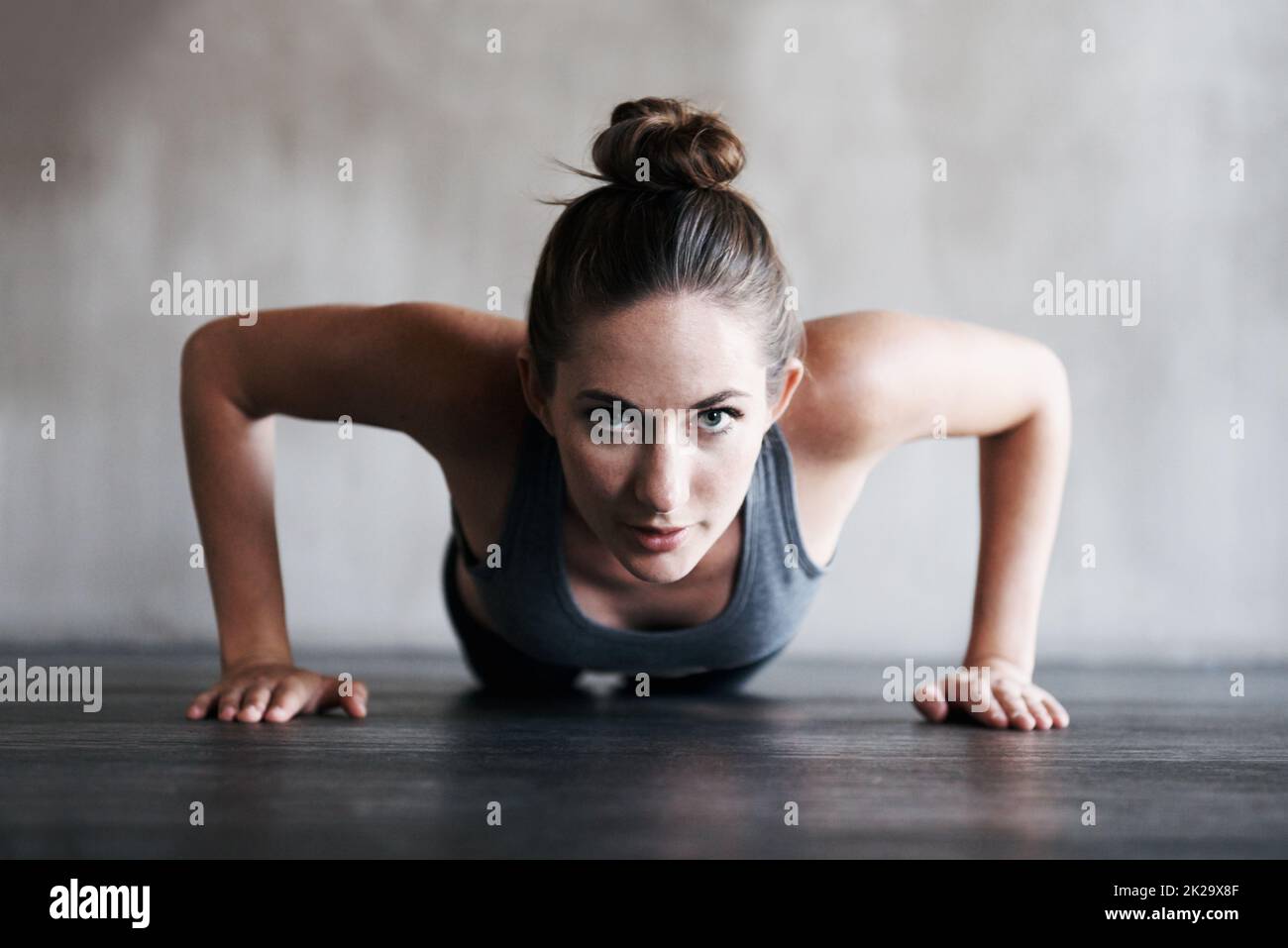 C'est dur, mais ça en vaut la peine. Photo d'une femme qui fait des poussettes à la salle de gym. Banque D'Images