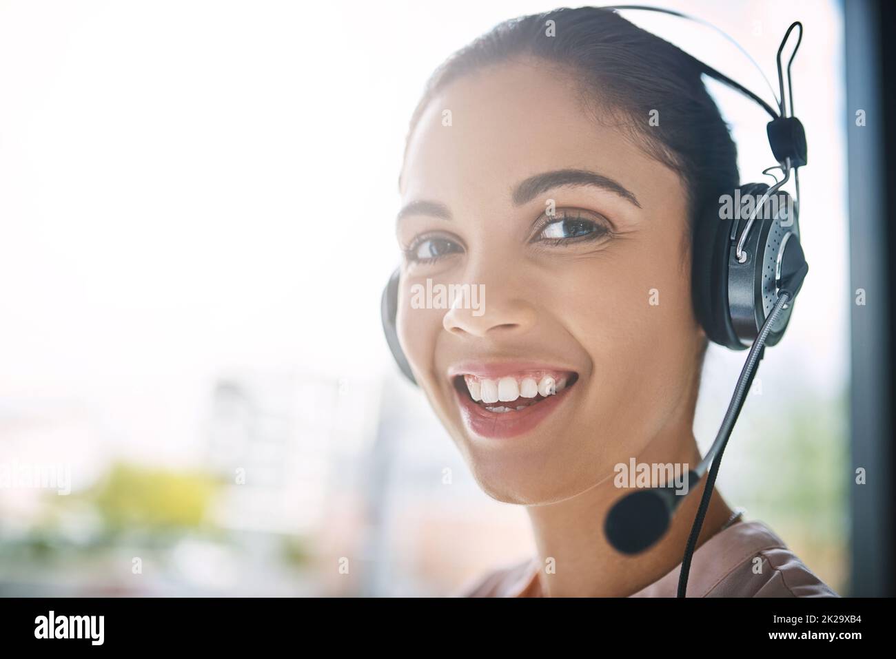 Comment puis-je diriger votre appel ? Portrait rogné d'une jeune femme attrayante travaillant dans un centre d'appels. Banque D'Images