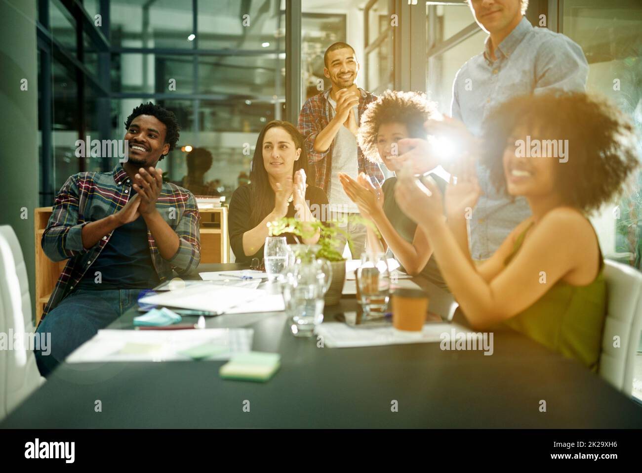 L'innovation mérite des applaudissements. Photo d'une équipe d'hommes d'affaires créatifs qui applaudissent une réussite tout en travaillant tard dans la salle de conférence. Banque D'Images
