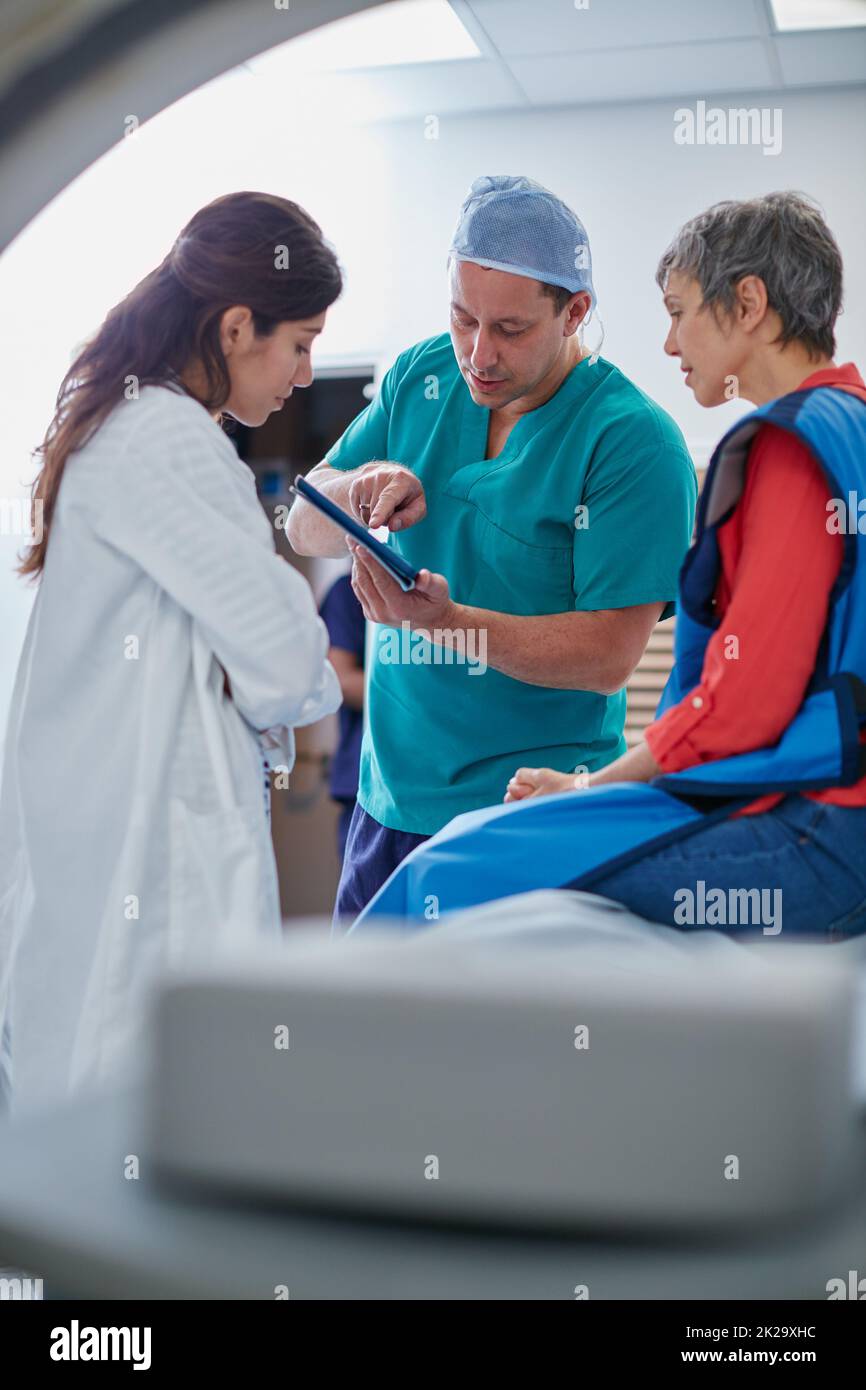 C'est donc ce que nous avons trouvé. Photo d'une femme mûre discutant avec des médecins avant et IRM. Banque D'Images