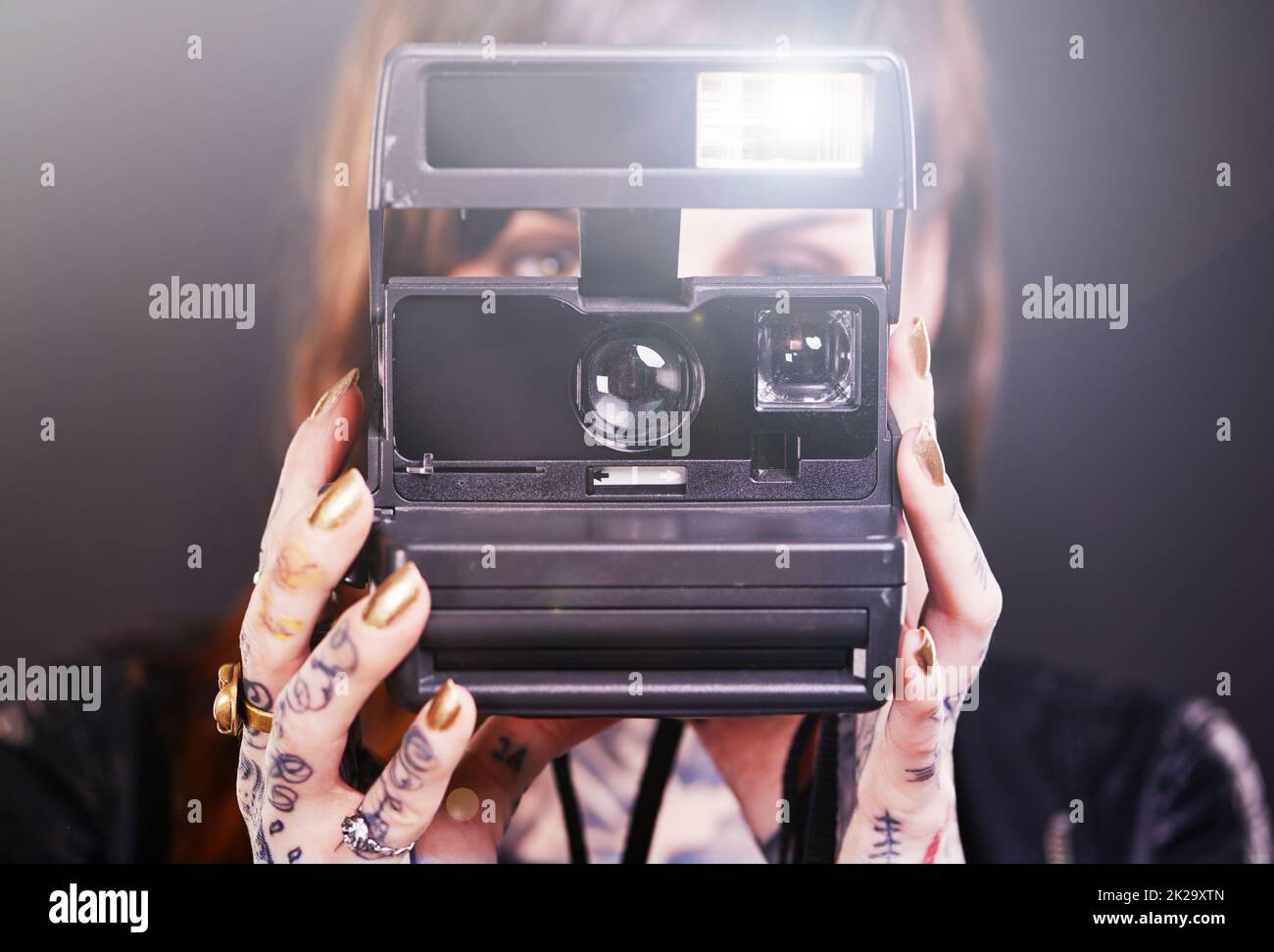 Capturer un moment. Photo en studio d'une jeune femme tatouée portant un appareil photo d'époque Banque D'Images