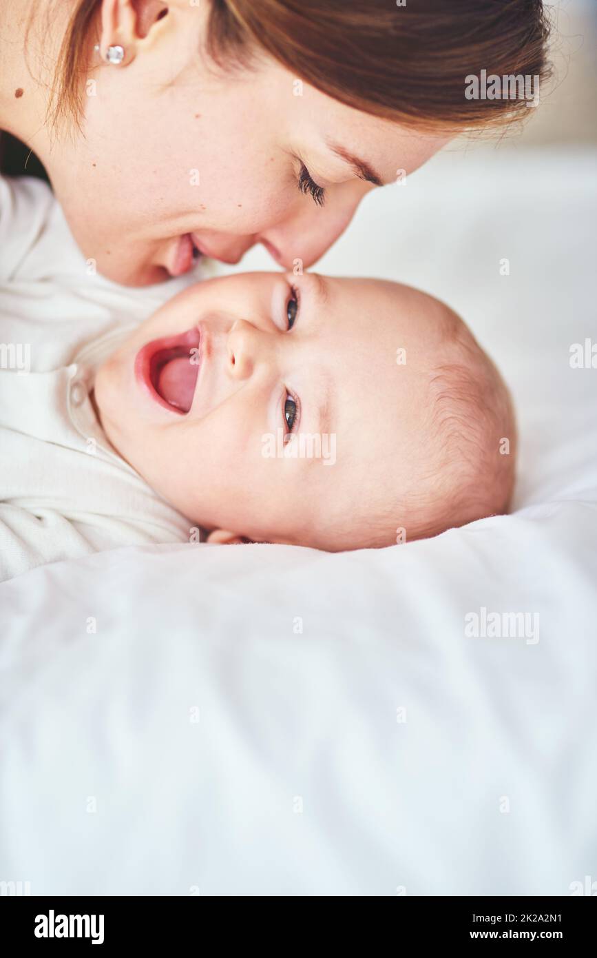 Ça a du tickle, maman. Photo d'une jeune mère qui se joint à son adorable bébé garçon à la maison. Banque D'Images