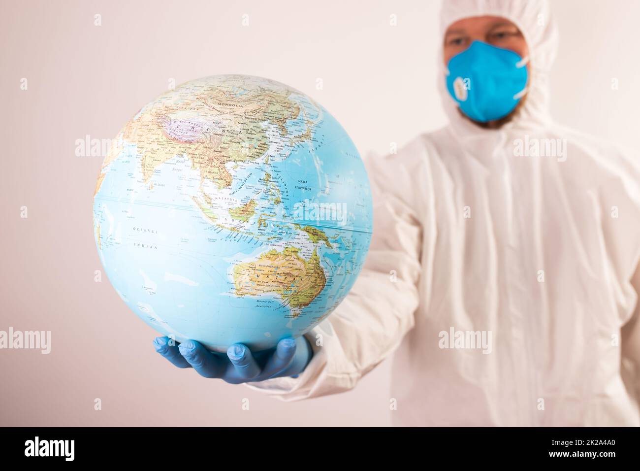 Médecin tenant la planète Terre dans un masque médical. Banque D'Images