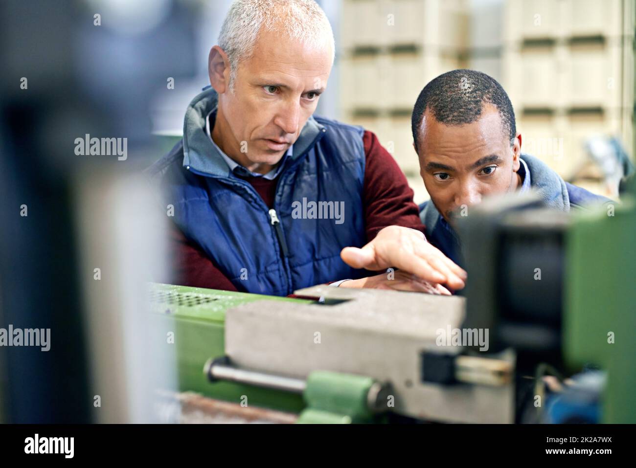 Étaient aussi bons que notre équipement. Photo de deux hommes travaillant sur des machines d'usine. Banque D'Images