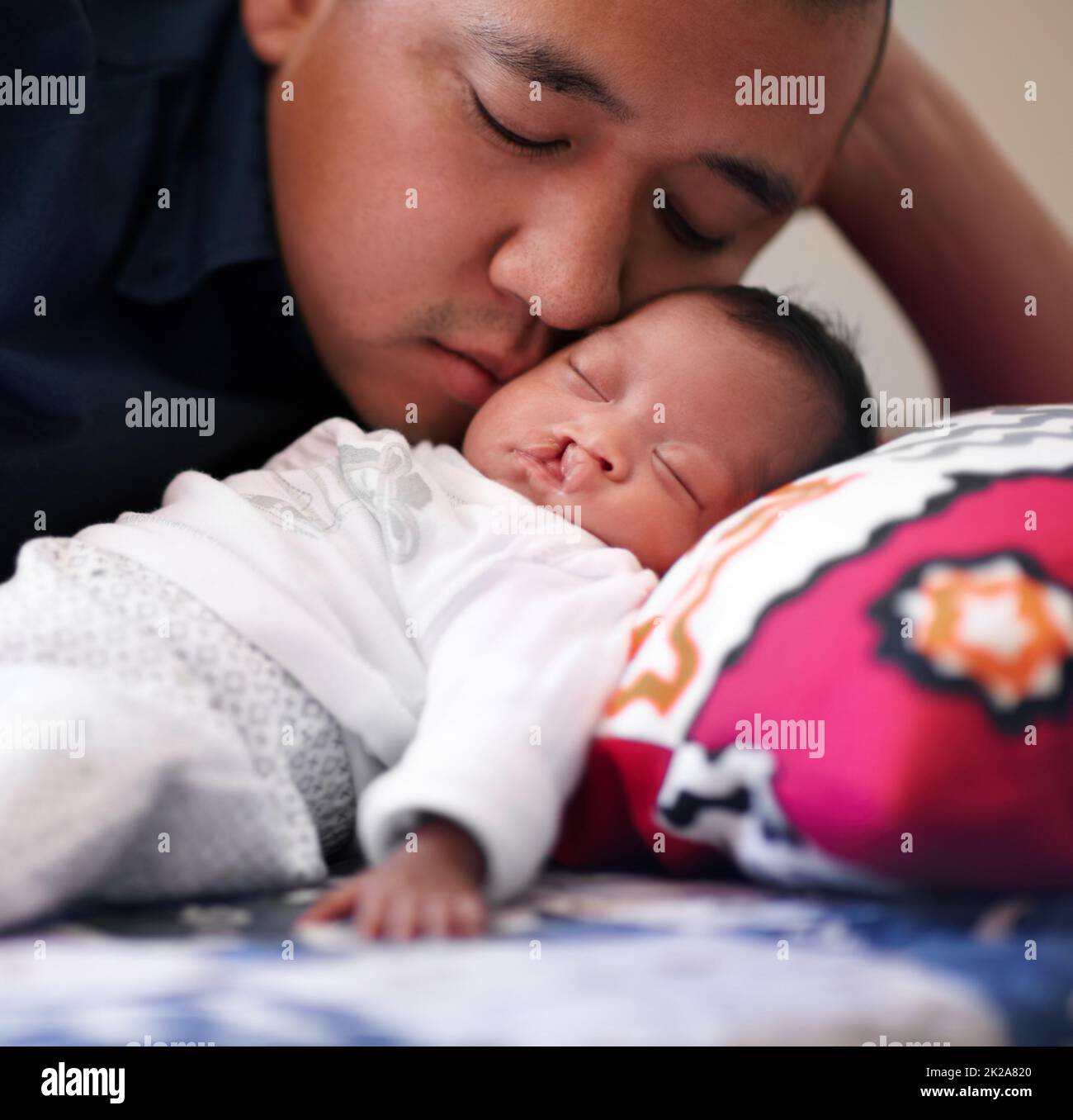 Sous le regard affectueux de son père. Photo d'un jeune père qui se joint à sa petite fille qui a un palais de fente. Banque D'Images