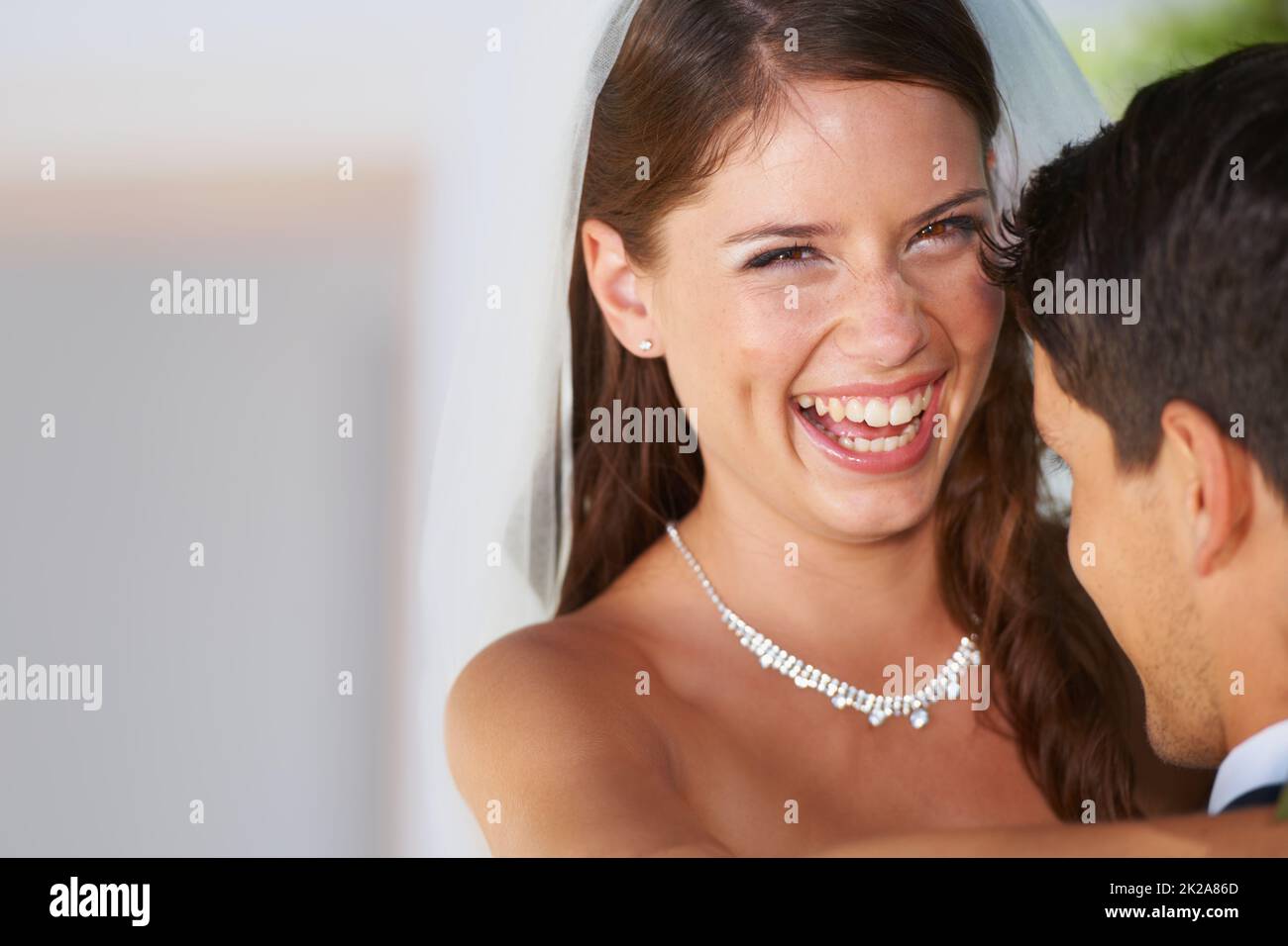 Ils ont été faits les uns pour les autres. Portrait d'une jeune mariée ravie qui embrasse son mari. Banque D'Images