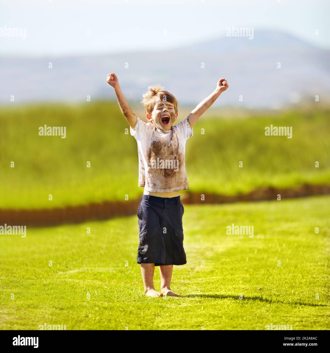 Je suis le gagnant. Un petit garçon mignon qui applaudisse en plein air. Banque D'Images