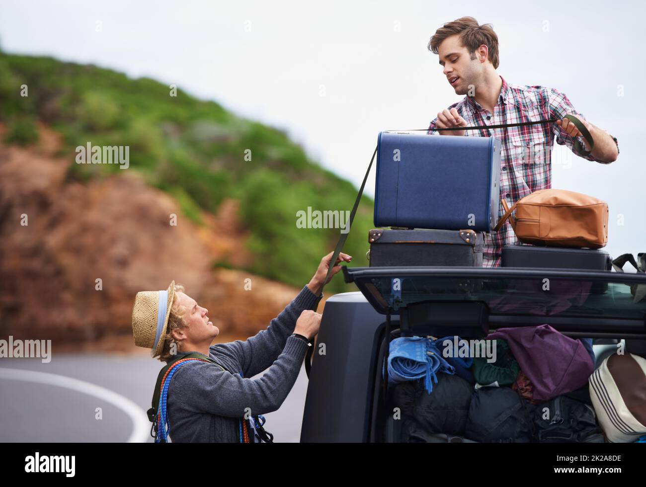 Pensez que nous avons apporté trop. Deux jeunes hommes se sont arrêtés sur le côté de la route et ont rembalé leur camion. Banque D'Images