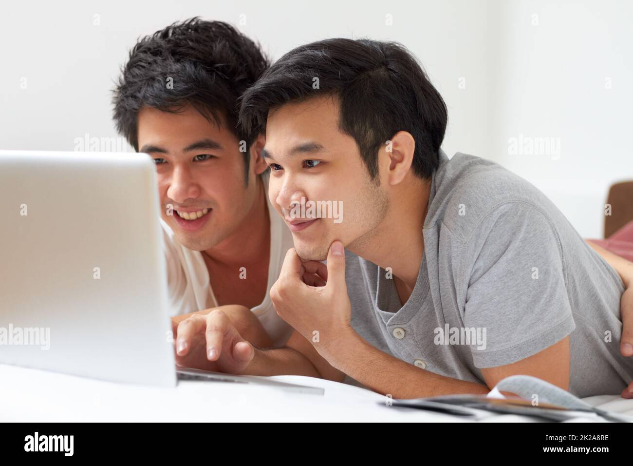 Trouver tout ce que l'on cherche Deux jeunes asiatiques qui recherchent ensemble Internet sur un ordinateur portable. Banque D'Images
