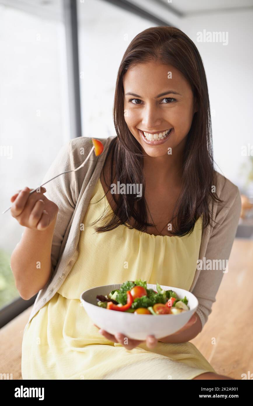 Un en-cas sain. Une jolie jeune femme qui apprécie une salade saine. Banque D'Images