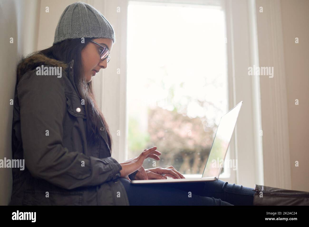 Mettre ses pensées dans son blog. Une jeune femme utilisant son ordinateur portable à la maison. Banque D'Images