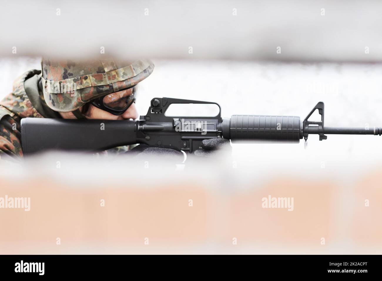 Shooter vif. Profil d'un soldat visant un fusil avec une fente au premier plan. Banque D'Images