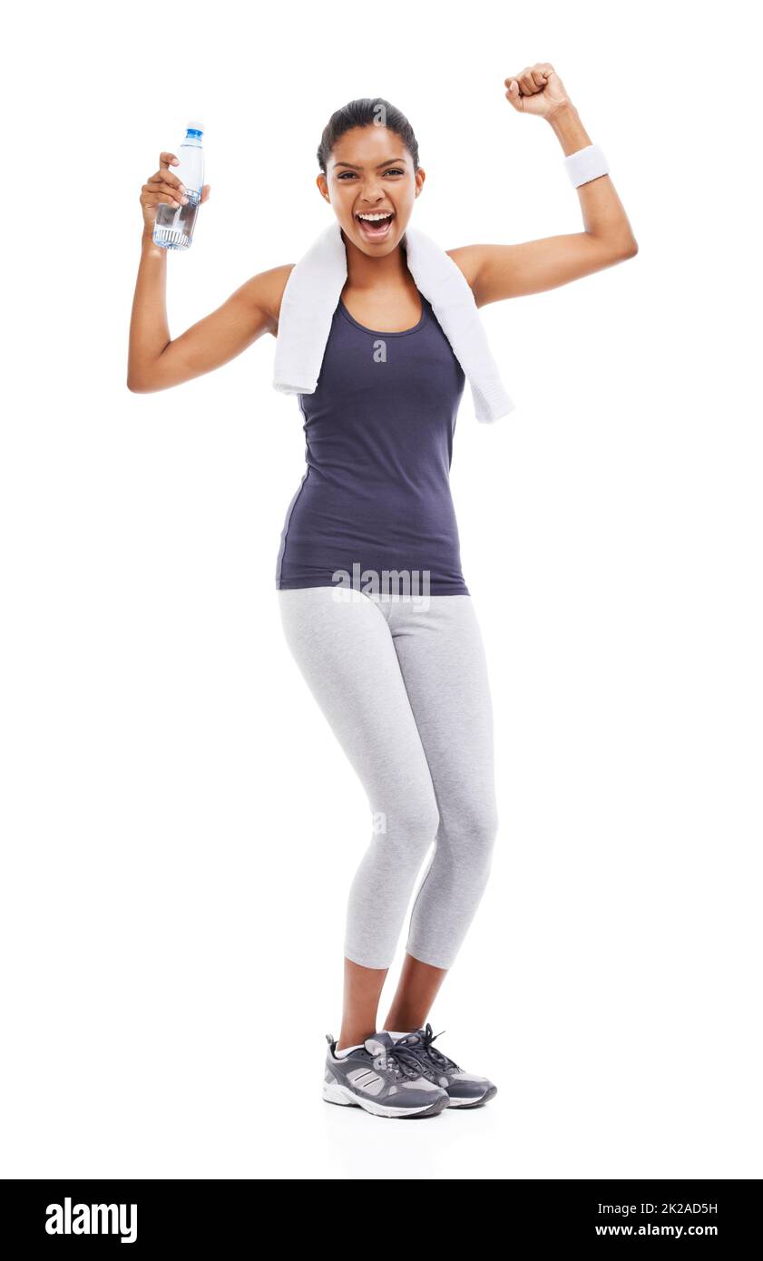 Shes atteint ses objectifs de forme physique. Une jeune femme tenant une bouteille d'eau et fléchissant ses biceps après un entraînement stimulant. Banque D'Images