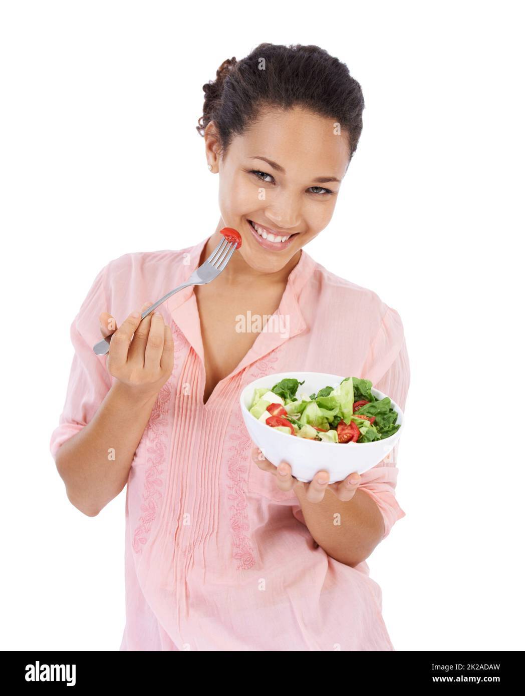 Faire le choix sain et avoir une salade. Jeune femme souriant tout en mangeant une salade verte fraîche. Banque D'Images