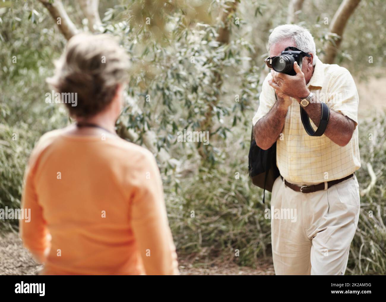 Vous avez l'air beau. Un homme âgé qui prend une photo de sa femme pendant qu'il est dehors pour une promenade pendant leurs vacances. Banque D'Images