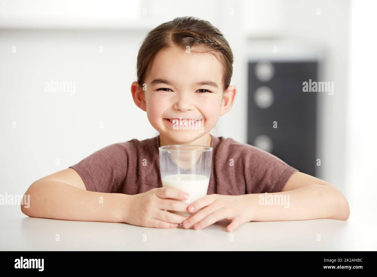 Des os sains, des enfants heureux. Portrait d'une petite fille mignonne appréciant un verre de lait. Banque D'Images