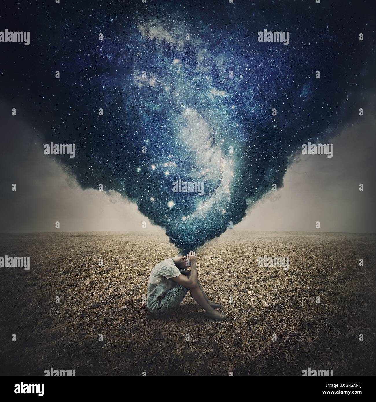 État d'esprit et de santé mentale concept comme une personne solitaire mélancholique assis dans une terre ouverte souffre de l'épuisement. Le smog sombre sort de la tête de l'homme et se transforme en une galaxie de pensées Banque D'Images