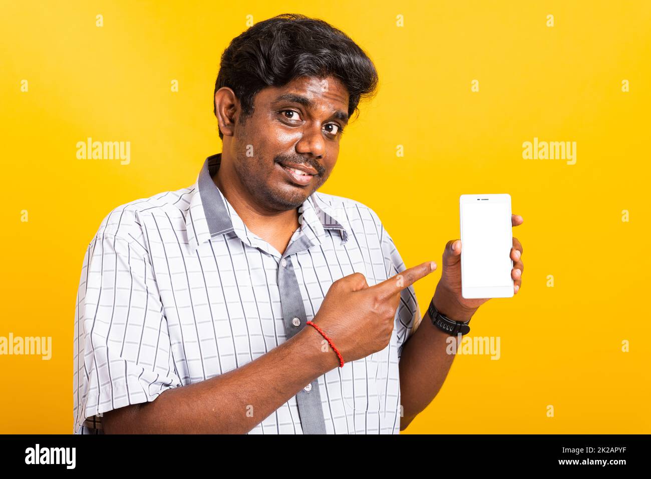 noir homme sourire debout porter chemise faire le doigt pointant sur téléphone portable numérique intelligent Banque D'Images