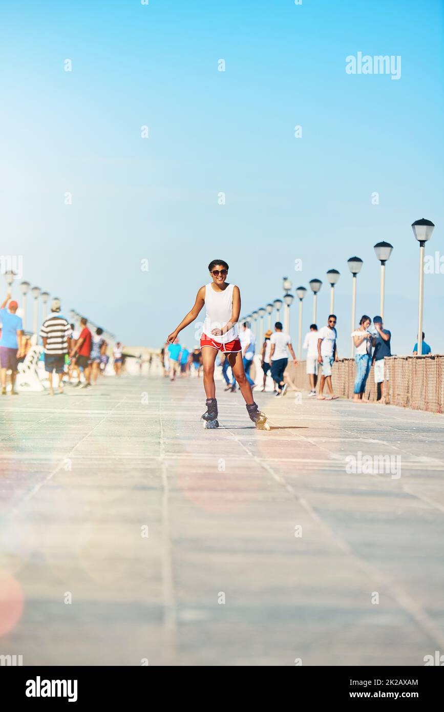 La meilleure façon de commencer la journée. Photo d'une jeune femme attirante en roller sur une promenade. Banque D'Images