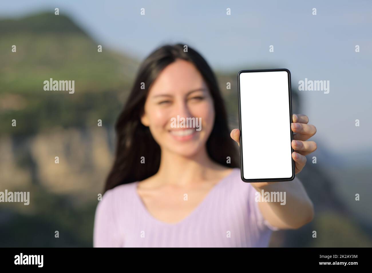 Bonne femme asiatique montrant un écran de smartphone vierge Banque D'Images