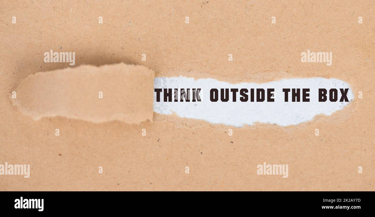 Pensez à l'extérieur de la boîte est debout sur des morceaux de papier, brainstorming pour de nouvelles idées, étant innovant, concept d'affaires Banque D'Images