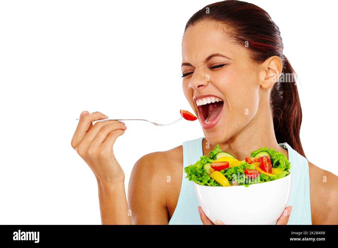 La salade est la meilleure. Portrait d'une jeune femme attrayante mangeant une salade saine avec ses yeux fermés. Banque D'Images