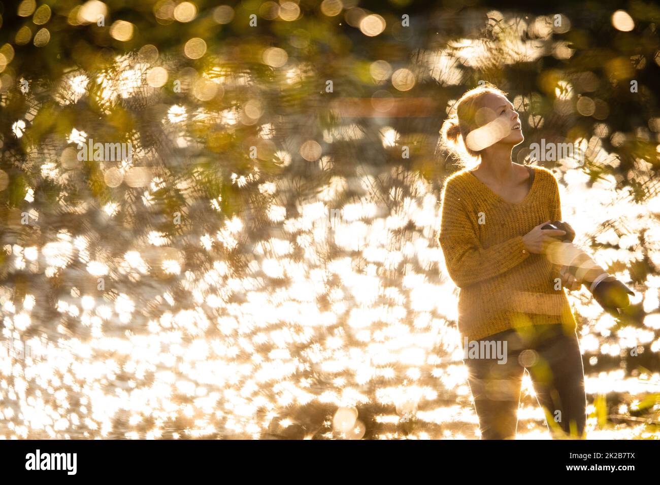Jolie femme photographe à prendre des photos en plein air, sur une belle journée d'automne - DOF peu profond, couleur tonique libre Banque D'Images