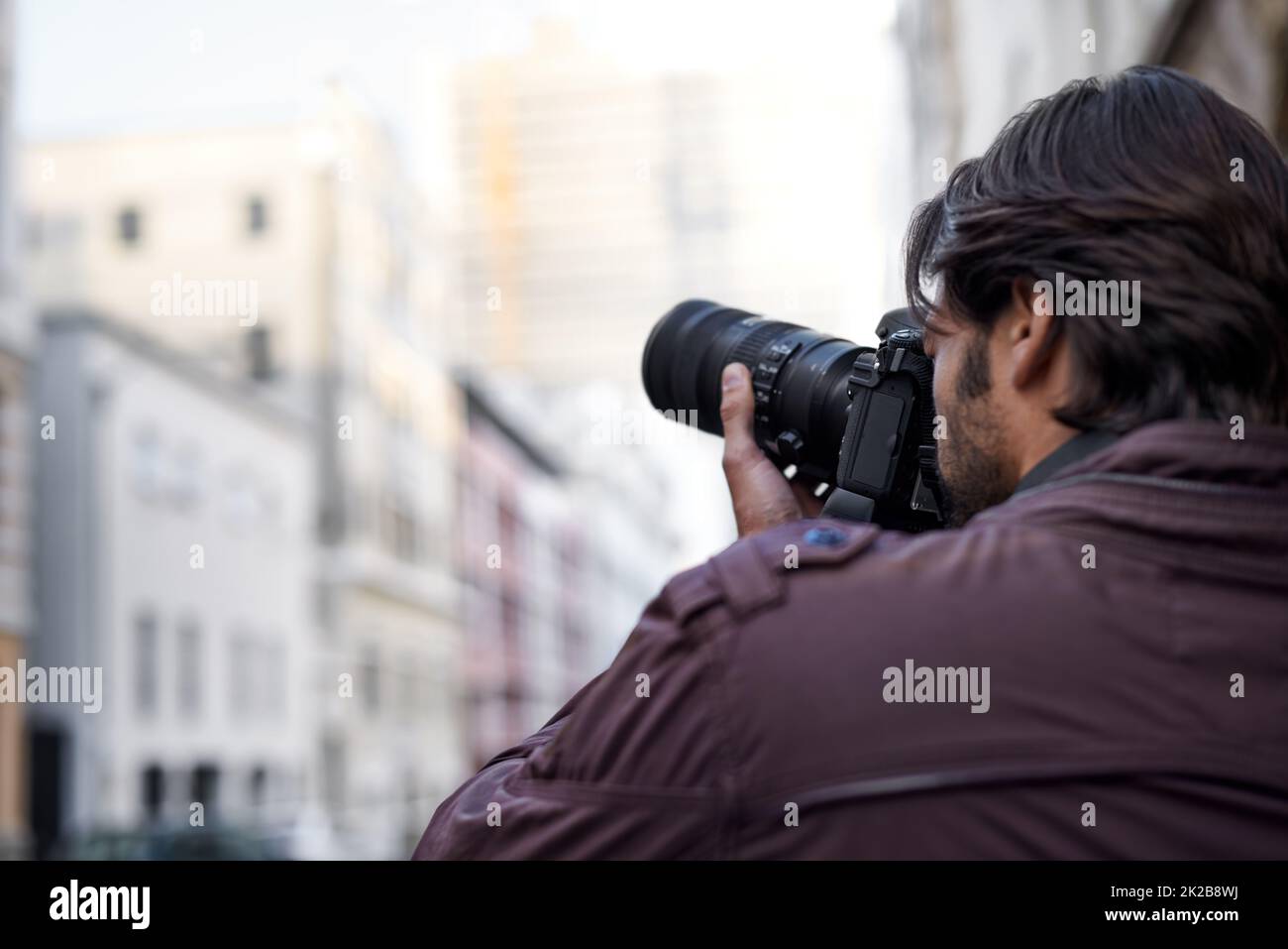 Capturer la beauté qui l'entoure. Un jeune homme prenant une photo avec son appareil photo. Banque D'Images