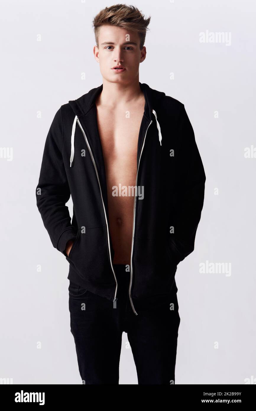 Modèle de mode pour homme. Portrait studio d'un jeune homme attrayant portant un sweat à capuche debout avec les mains dans les poches. Banque D'Images