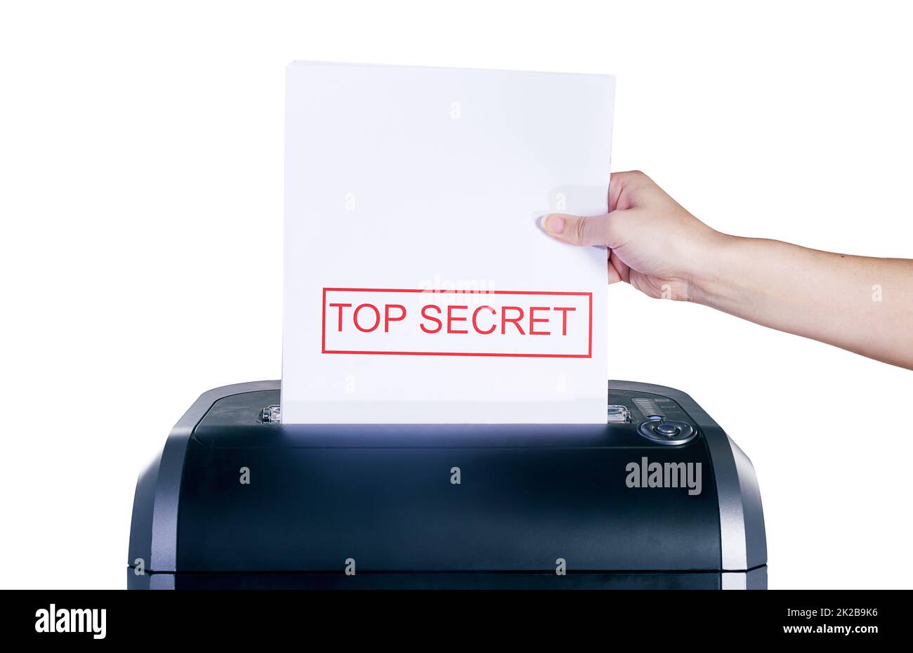 Se débarrasser des informations top secret. Photo en studio d'une main de femme plaçant un document confidentiel dans un destructeur sur un fond blanc. Banque D'Images