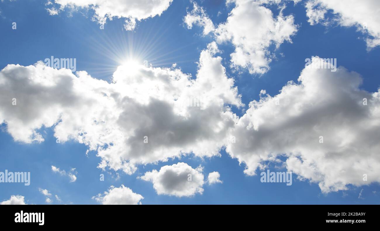 Nuages et soleil. Une photo d'un ciel bleu, de nuages et de soleil. Banque D'Images