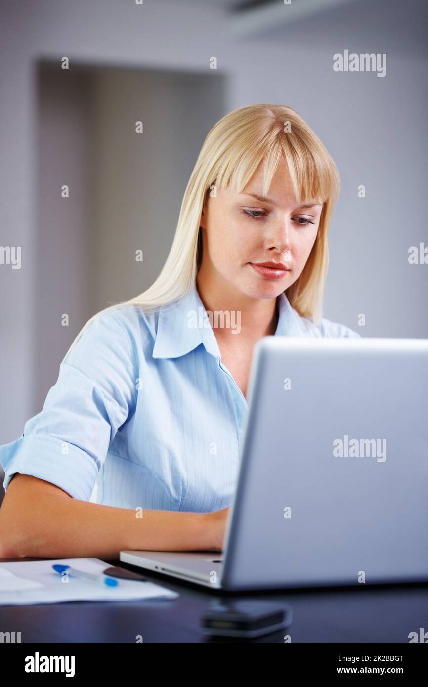 Travailler dur sur la présentation. Jeune femme d'affaires occupée avec son travail sur ordinateur portable. Banque D'Images