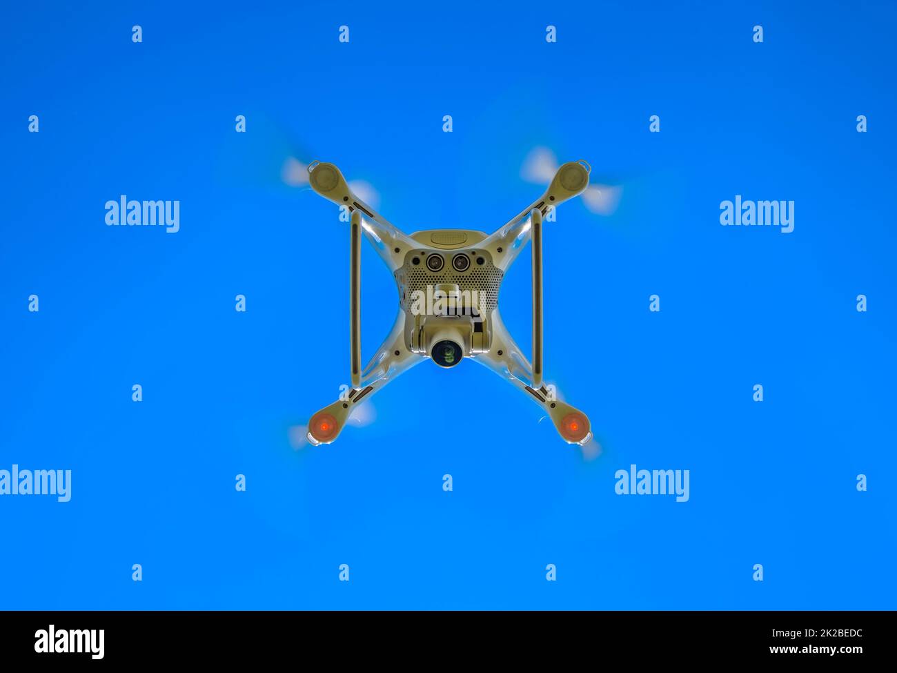 Drone DJI Phantom 4 en vol. Quadrocopter contre le ciel bleu Banque D'Images