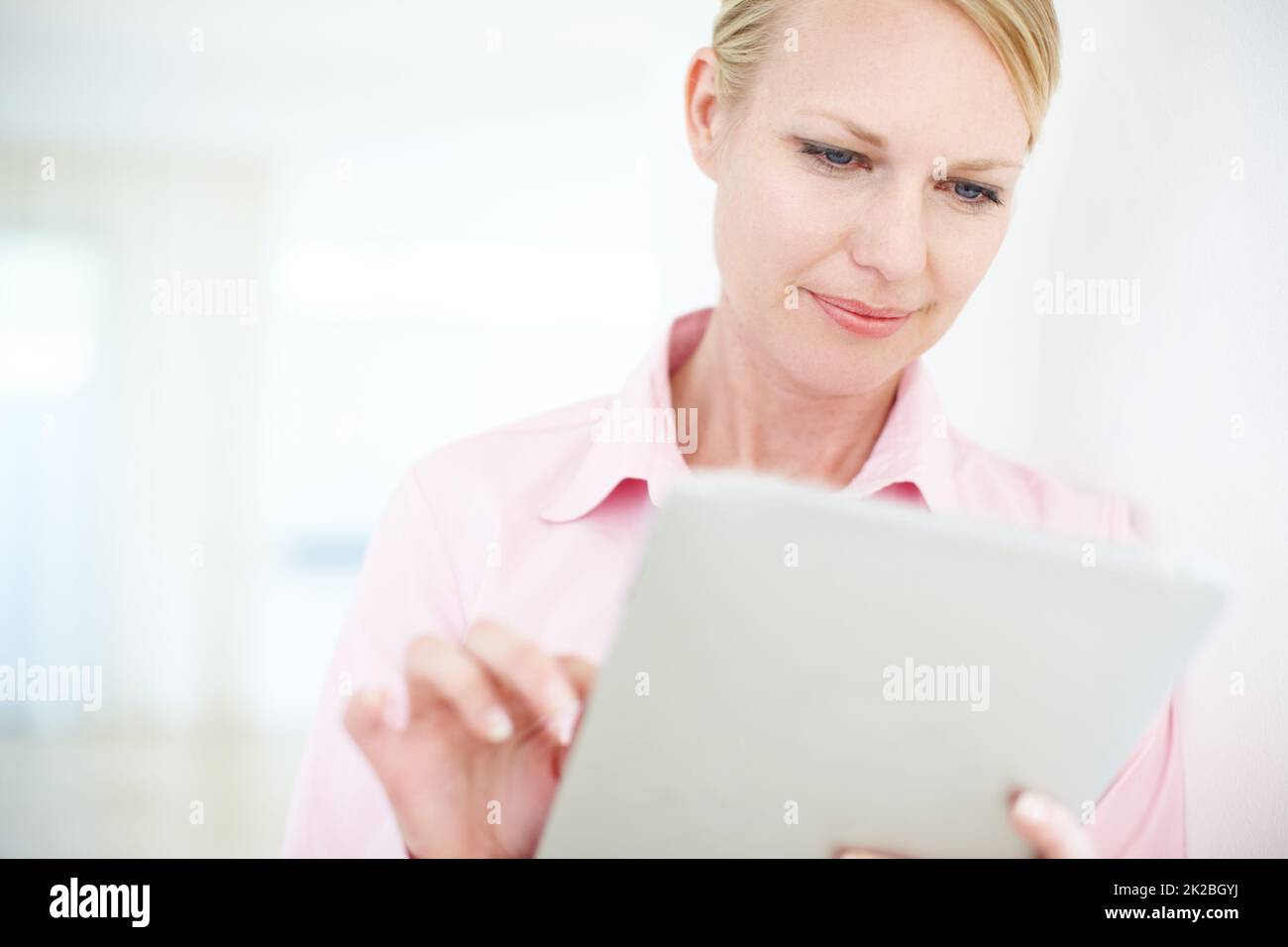 Suivi de ses ventes en ligne. Une jeune femme d'affaires attirante utilisant une tablette numérique. Banque D'Images