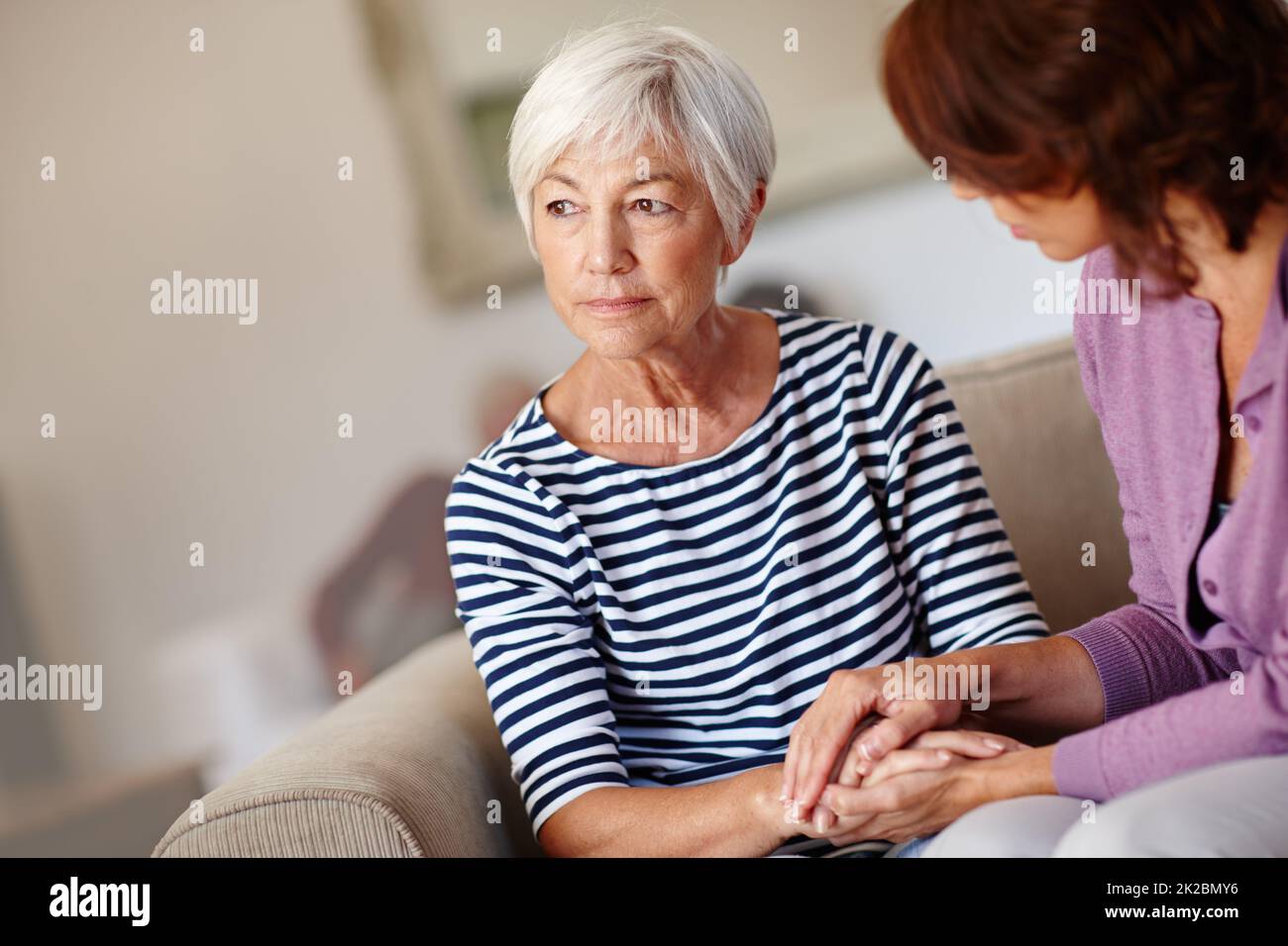 Inquiet pour l'avenir. Photo d'une femme assise à côté de sa mère âgée à la maison. Banque D'Images